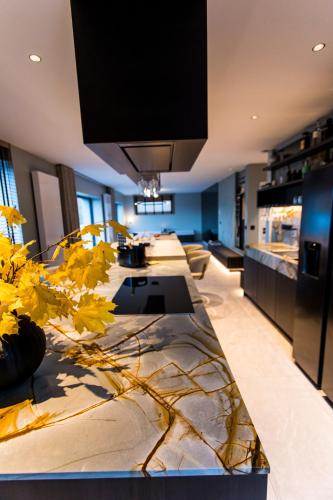 a living room with a long table with flowers on it at Loft La Suite et sa Suite in Thimister