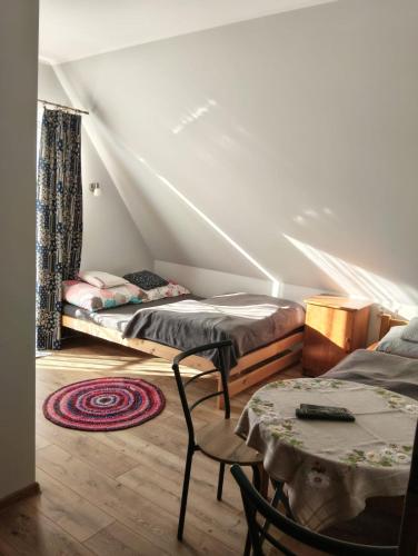 a room with two beds and a table and chairs at Widlakówka in Rzepiska