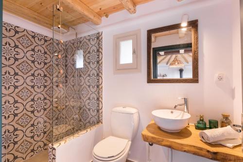 a bathroom with a sink and a toilet and a mirror at Luna Inn B&B in Corfu