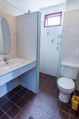 a bathroom with a toilet and a sink and a mirror at Hugs Guesthouse in Ko Lanta