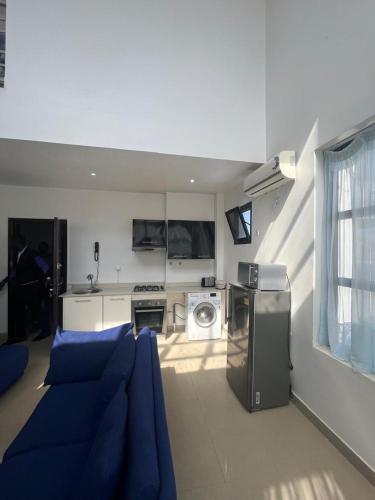 salon z niebieską kanapą i kuchnią w obiekcie Duplex Almadies w mieście Dakar