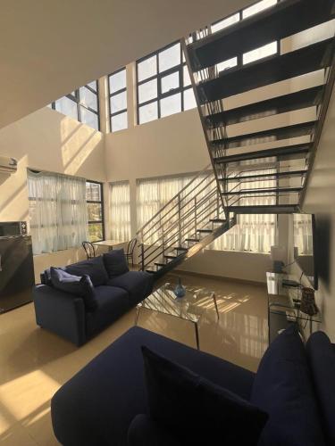 Una sala de estar con un sofá y una escalera. en Duplex Almadies, en Dakar