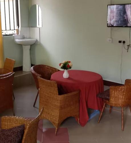 a room with a table with a vase of flowers on it at Mkula Executive Lodge in Mugumu