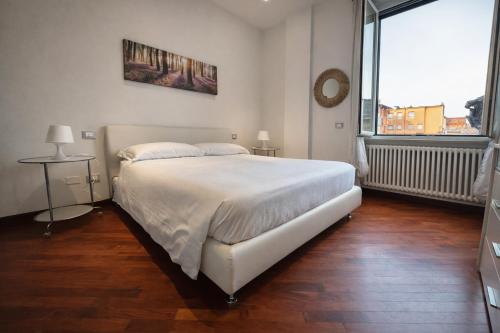 a bedroom with a white bed and a large window at Suite Mazzini in Ravenna