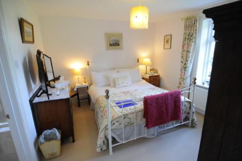 a bedroom with a bed and a desk and a window at Blackbrook House in Holmwood