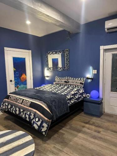 a blue bedroom with a bed and a mirror at 420 Friendly Suites in Washington, D.C.