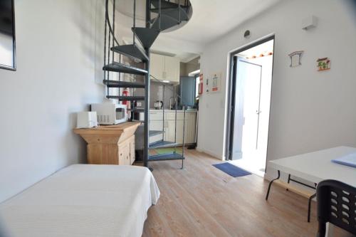 a room with a bed and a spiral staircase at Casinha in Sintra