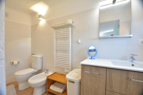 a bathroom with a toilet and a sink and a mirror at Casinha in Sintra