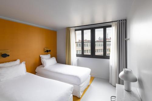 a hotel room with two beds and a window at People Lyon Hotel in Lyon