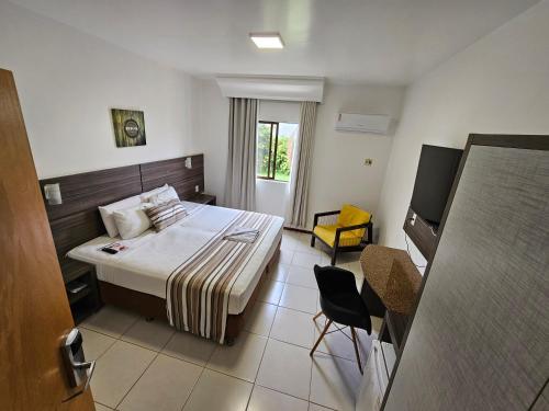 a hotel room with a bed and a chair at Solar Hotel Luis Eduardo Magalhães in Luís Eduardo Magalhães