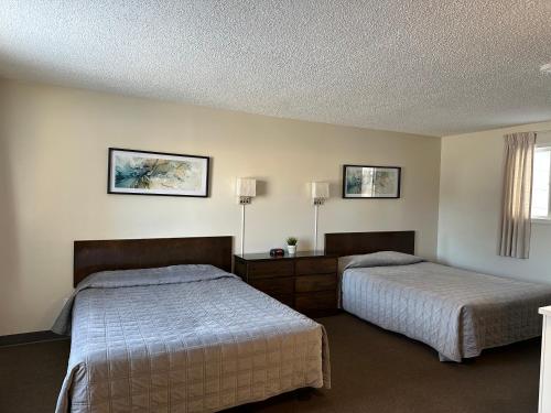 a bedroom with two beds and a window at Yellow Quill Motel in Portage La Prairie