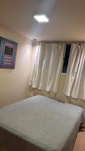 a bedroom with white curtains and a bed in it at Casa container Hermosa zona in Paraná