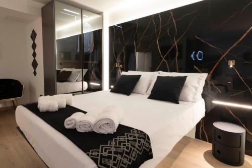 a bedroom with a large white bed with towels at Flá Suite Castello in Cagliari