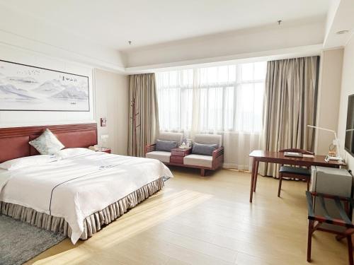 a hotel room with a bed and a desk at Shenzhen Xingwei Yifeng Hotel in Shenzhen