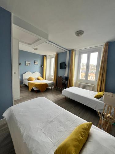 a hotel room with two beds and two windows at Hôtel de Bretagne in Redon