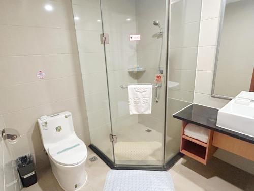 a bathroom with a shower and a toilet and a sink at Shenzhen Xingwei Yifeng Hotel in Shenzhen