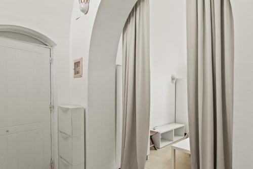 a white room with a mirror and a curtain at The Downtown Getaway Studio in Hurghada