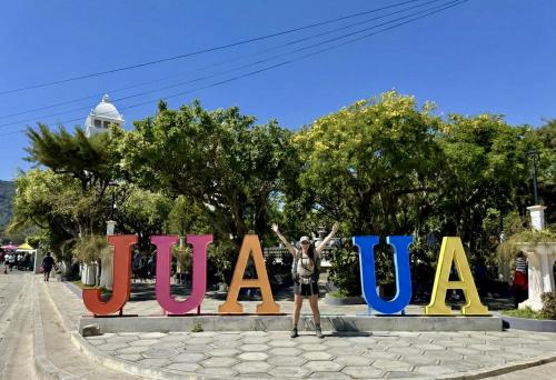 a woman standing in front of a large sign at Neska Polita Hostel in Juayúa