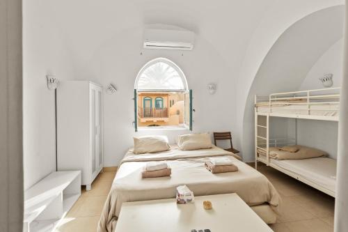 a white room with two beds and a window at The Downtown Getaway Studio in Hurghada