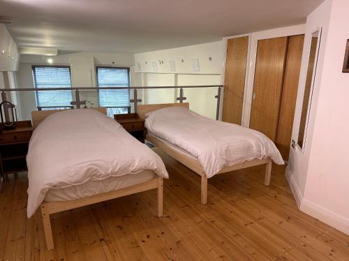 two beds in a room with wooden floors at City Centre 3 bedrooms apartment with parking in Nottingham