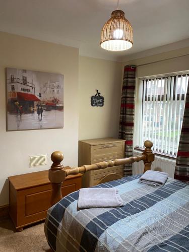 a bedroom with a bed and a pendant light at Ruckledge Terrace in Skegby