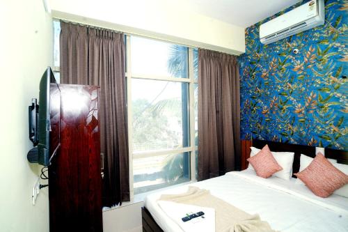 a hotel room with a bed and a window at Sri Sai comforts - Bannerghatta Main Road in Bangalore