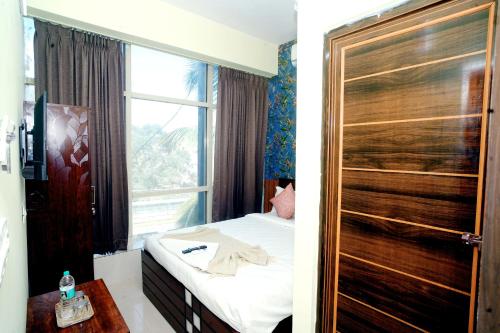 a hotel room with a bed and a window at Sri Sai comforts - Bannerghatta Main Road in Bangalore