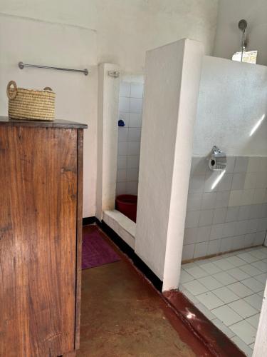 a bathroom with a shower with a red toilet at Maison Baby plein centre in Ambatoloaka