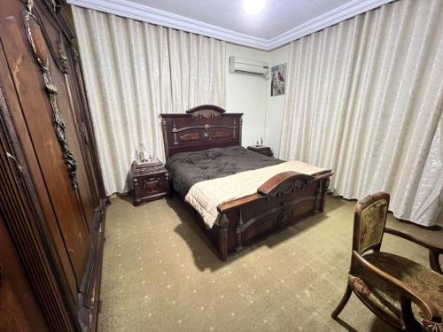 a bedroom with a bed and a dresser and a chair at Jad Apartment in irbid in Irbid