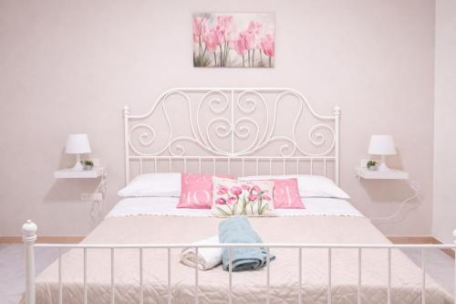 a bedroom with a white bed with pink and pink pillows at Il Tulipano Camera con bagno privato a Marcianise in Marcianise