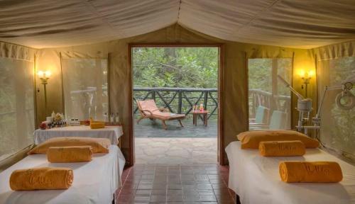 two beds in a room with a porch at Sekenani,Leparan Lodge in Narok