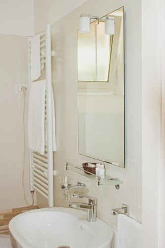 a white bathroom with a sink and a mirror at La Campina de Don Paulu in Galatina