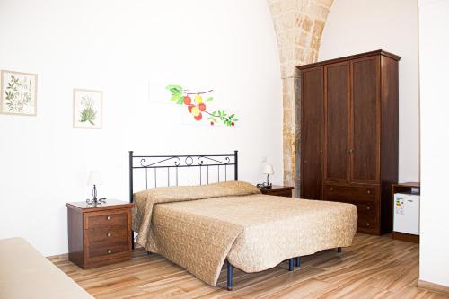 a bedroom with a bed and a wooden cabinet at La Campina de Don Paulu in Galatina