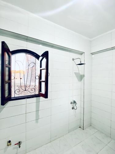 a bathroom with a shower and a window at Golden Rose Guesthouse in Luxor
