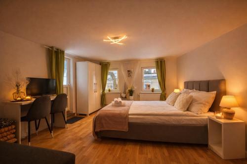 a bedroom with a bed and a desk and a television at Domek Przy Termach in Jelenia Góra