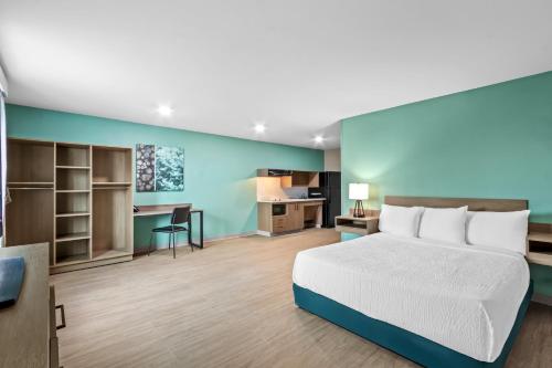 a hotel room with a bed and a desk at ECHO Suites Extended Stay by Wyndham Phoenix-Peoria/Glendale in Peoria