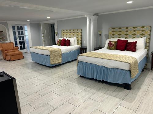 a hotel room with two beds and a chair at The Inn at Cedar Grove in Vicksburg