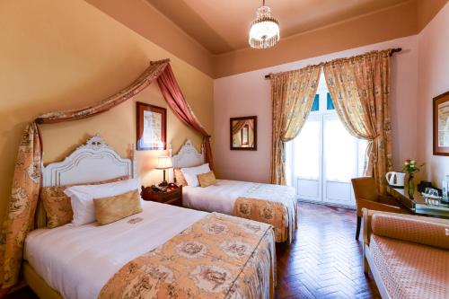 a hotel room with two beds and a window at Casa de Sao Mamede Hotel in Lisbon