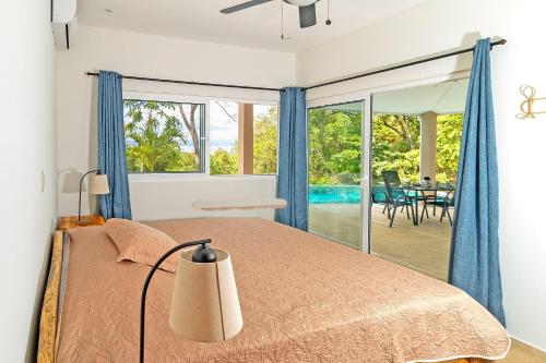 a bedroom with a bed and a view of a patio at Villas Roma Del Mar in Naranjo