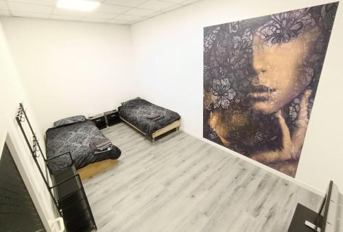 two beds in a room with a painting on the wall at 1 bedroom apartment 2 guests in Aschaffenburg