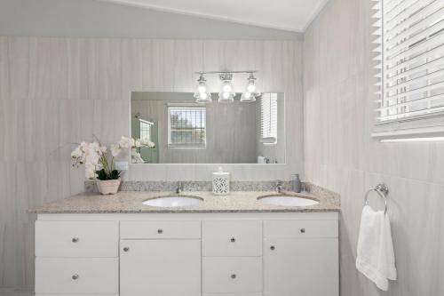 a white bathroom with two sinks and a mirror at Palasette Dover Gardens Barbados in Christ Church