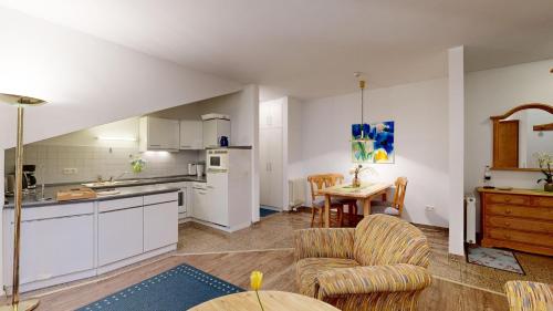 a kitchen and living room with a table and chairs at strandnahe FeWo mit Schwimmbad im Haus, a cappella 07, Binz in Binz