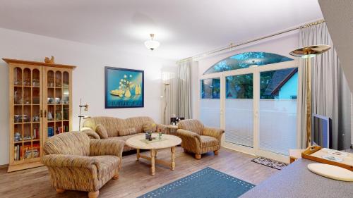a living room with a couch and chairs and a table at strandnahe FeWo mit Schwimmbad im Haus, a cappella 07, Binz in Binz