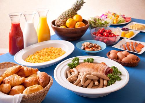 a blue table topped with bowls of different types of food at Hotel Plaza Kachigawa in Kasugai