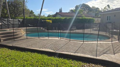 a batting cage in a backyard with a pool at Charming House with Private Pool n Coral Gable in Miami
