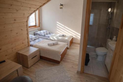 a small room with two beds and a bathroom at Pod Tatrami widok na Tatry, sauna, parking, blisko Term Bukovina in Bukowina Tatrzańska