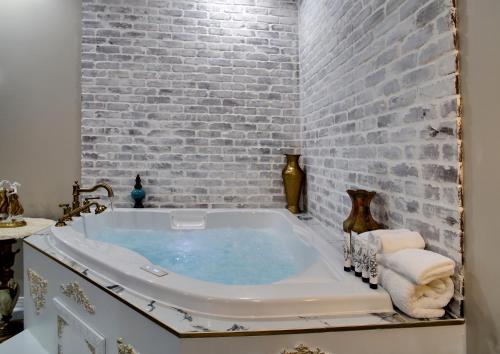 a bathroom with a bath tub with a brick wall at McMillan Inn in Savannah