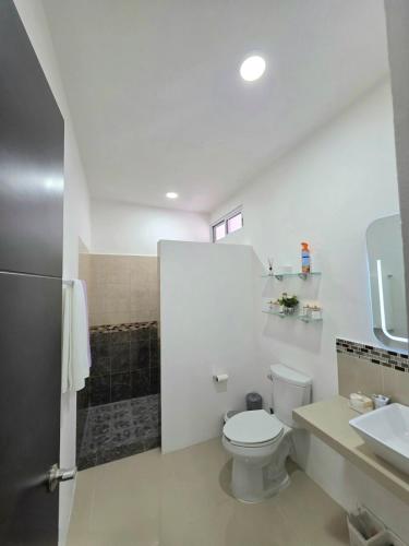 a white bathroom with a toilet and a sink at Sweethome Mérida in Mérida