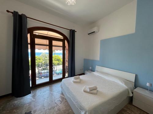 a bedroom with a bed and a large window at Case Vacanze Bedda Iole in Canneto