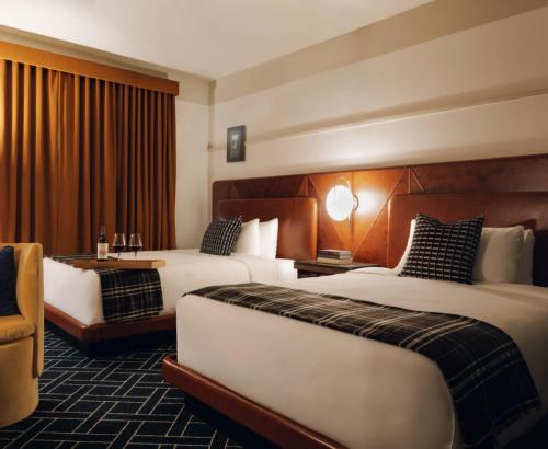 a hotel room with two beds and a desk at Caravan Court Hotel in Arlington